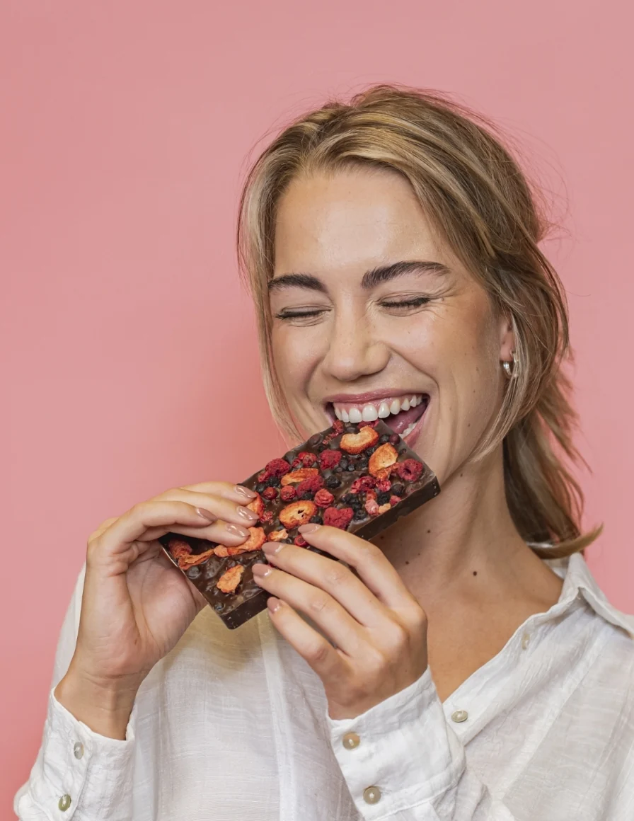 Een vrouw die een chocolade reep aan het eten is